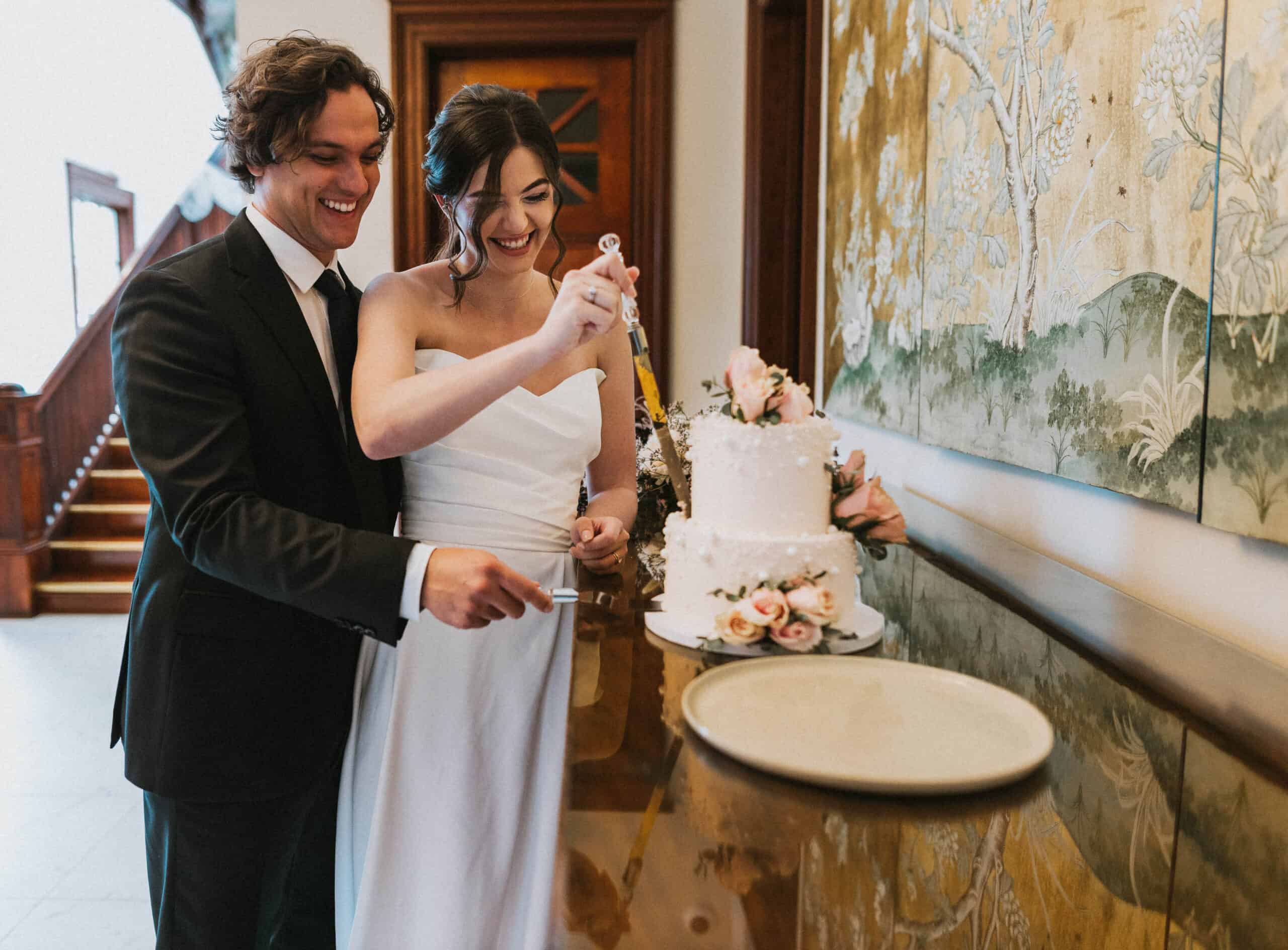 laughing bride and groom cutting the cake