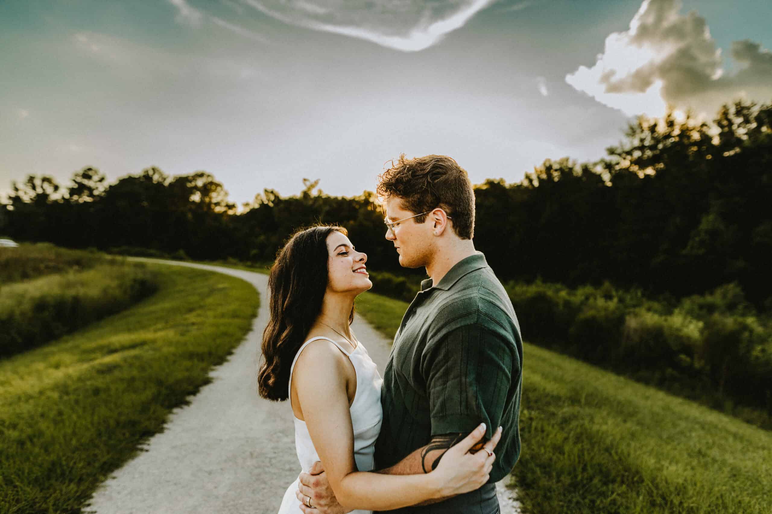 young couple smiling at each other against the backdrop of stunning scenery