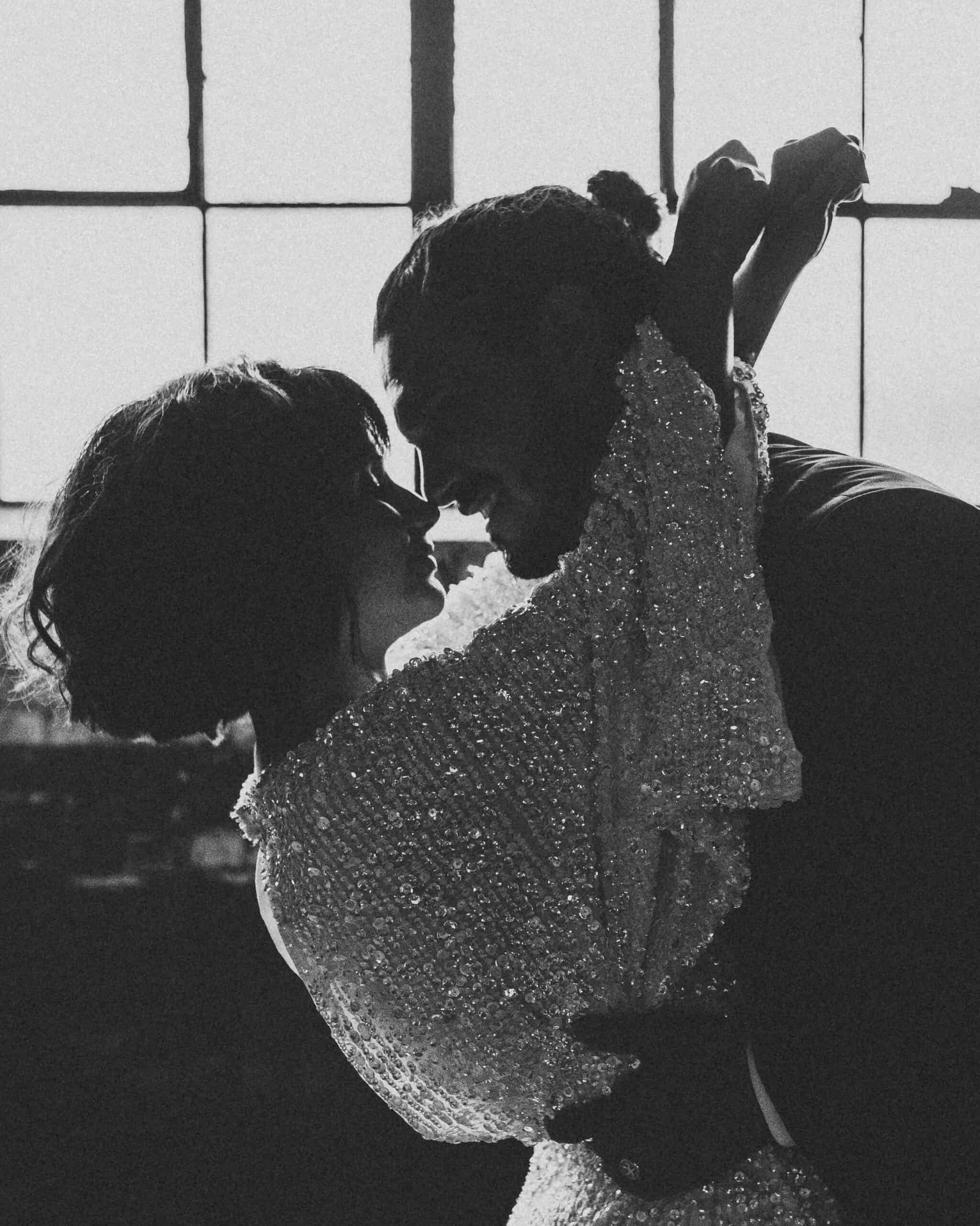 black and white photo of the bride and groom hugging