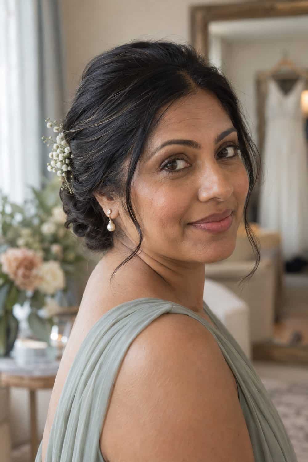 adult bridesmaid, South Asian woman aged about 38 with warm brown skin, minimal peach corrector beneath the eyes, sheer base, soft brown mascara and rose balm, hair kept simply away from the face, unretouched real skin texture